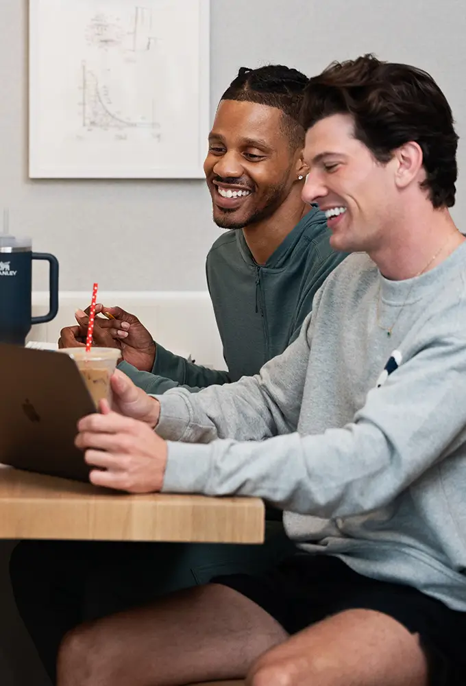 two friends using a laptop