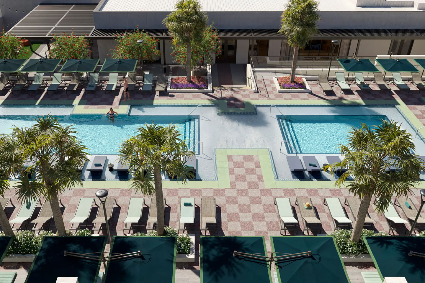 Pool area with two pools and chairs surrounding them and palm trees.
